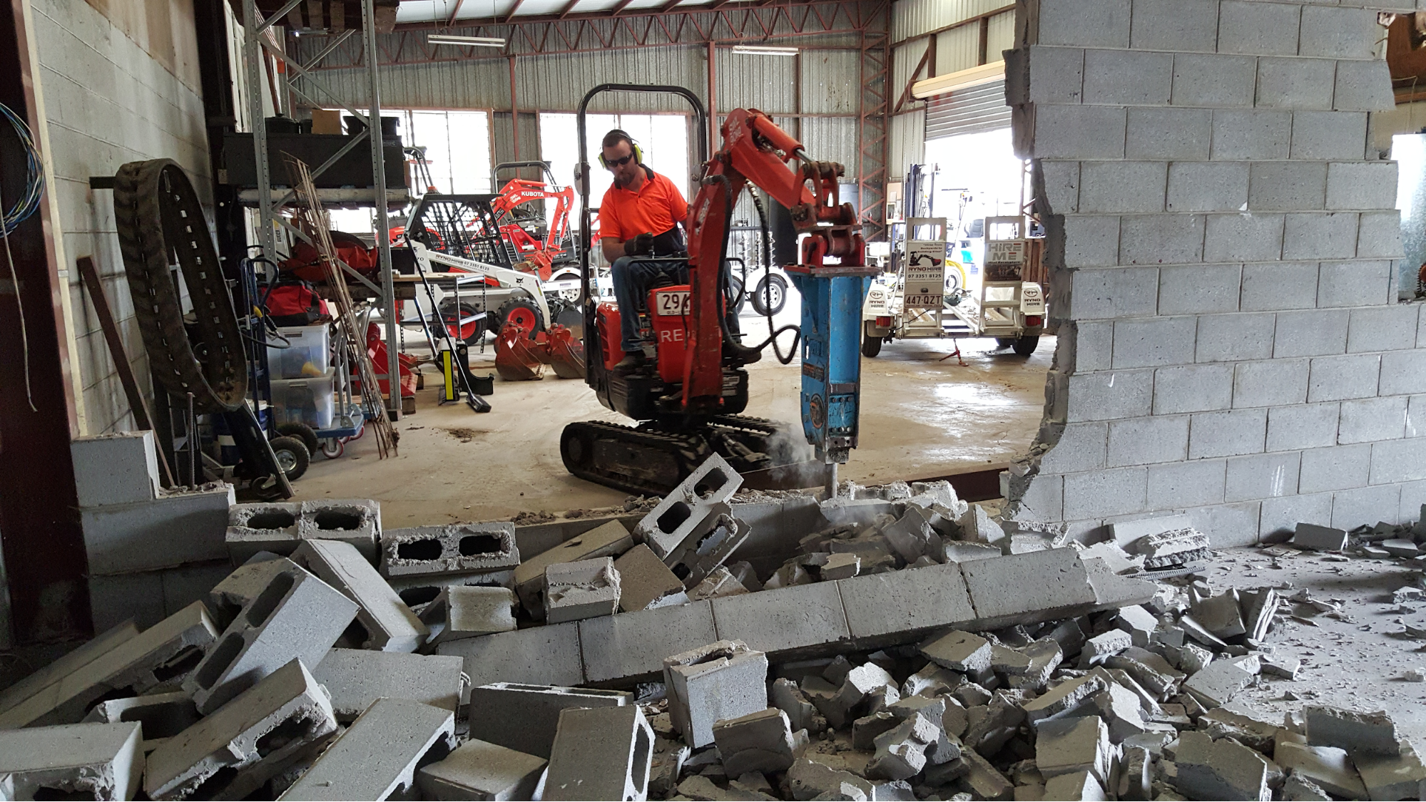 A man is operating an excavator with auger drivers attachment