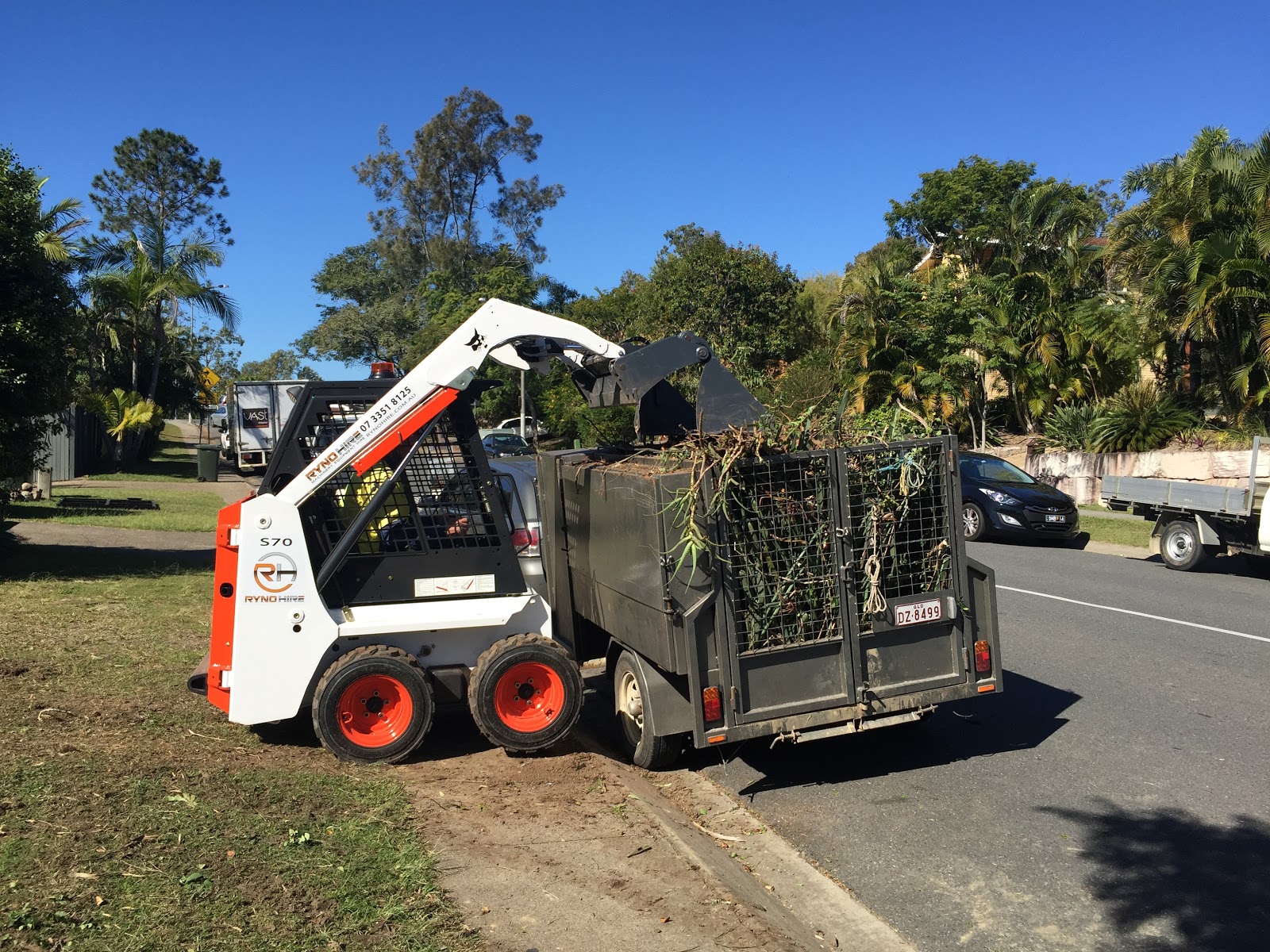 An excavator is tipping grass