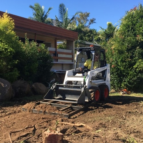 A trader is operating Bobcat loader on soil ground