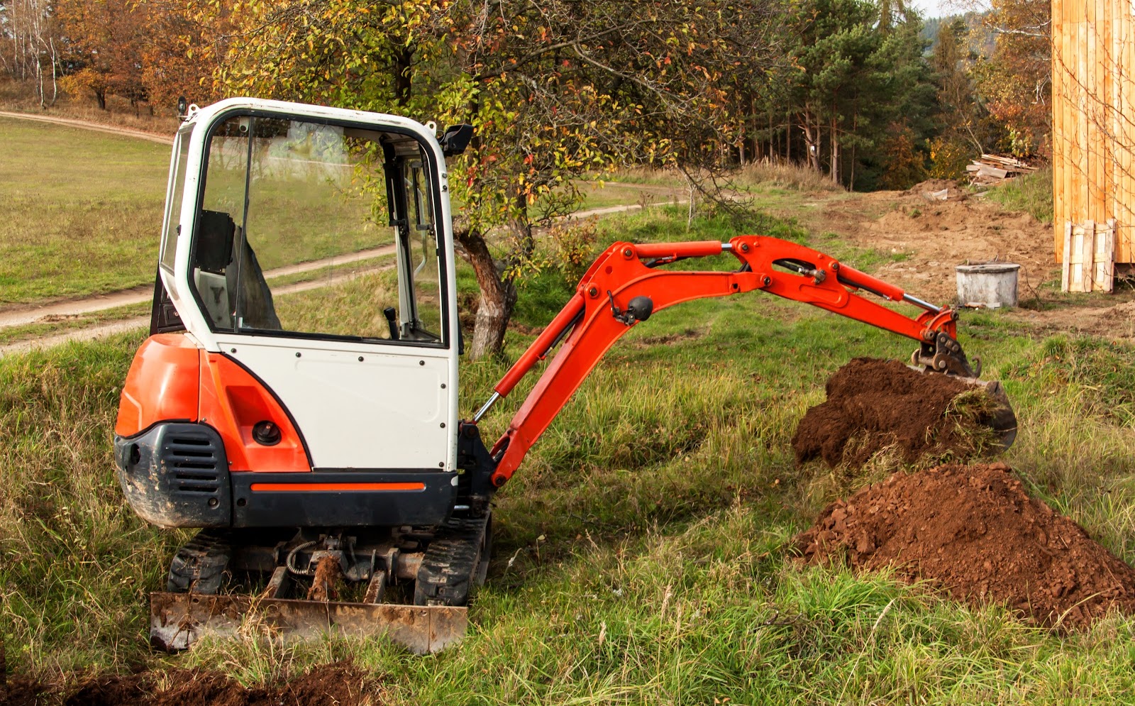 mini excavator on backyard moving soil dump