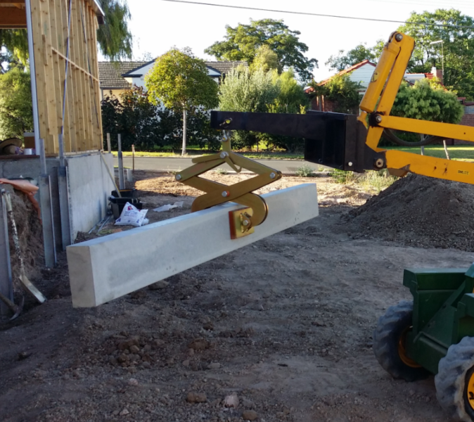 An excavator is lifting a piece of cement block using concrete sleeper grab
