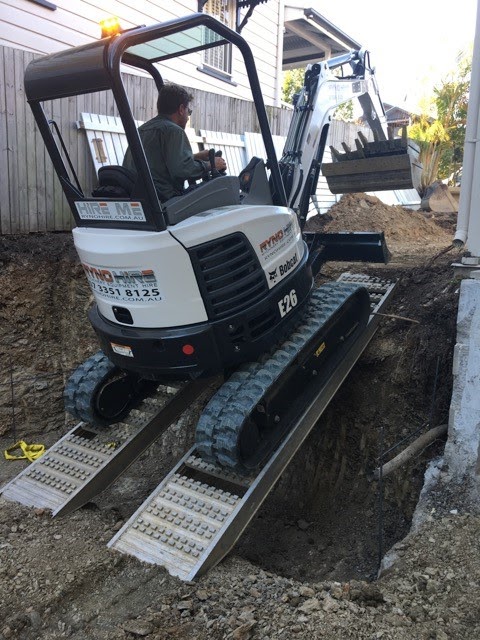 A man is operating an excavator and using loading Ramps excavator