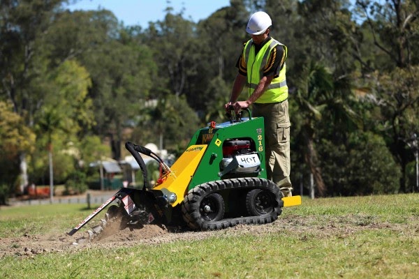 A man is operating micro loader on a ground