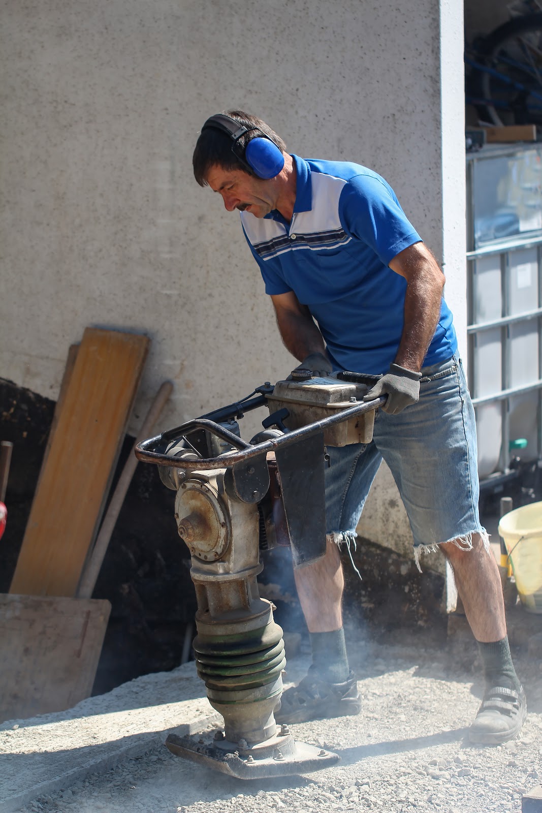 A man is operating soil compactor on the ground