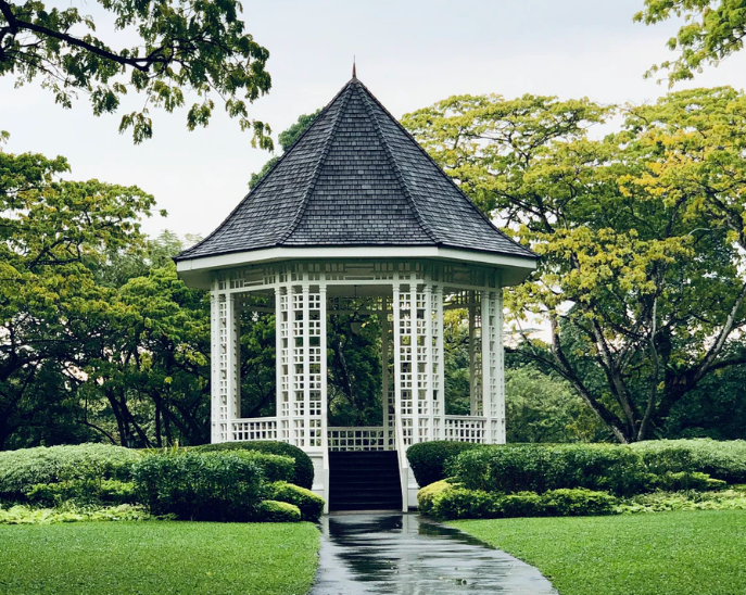A black and white painted gazebo in a garden