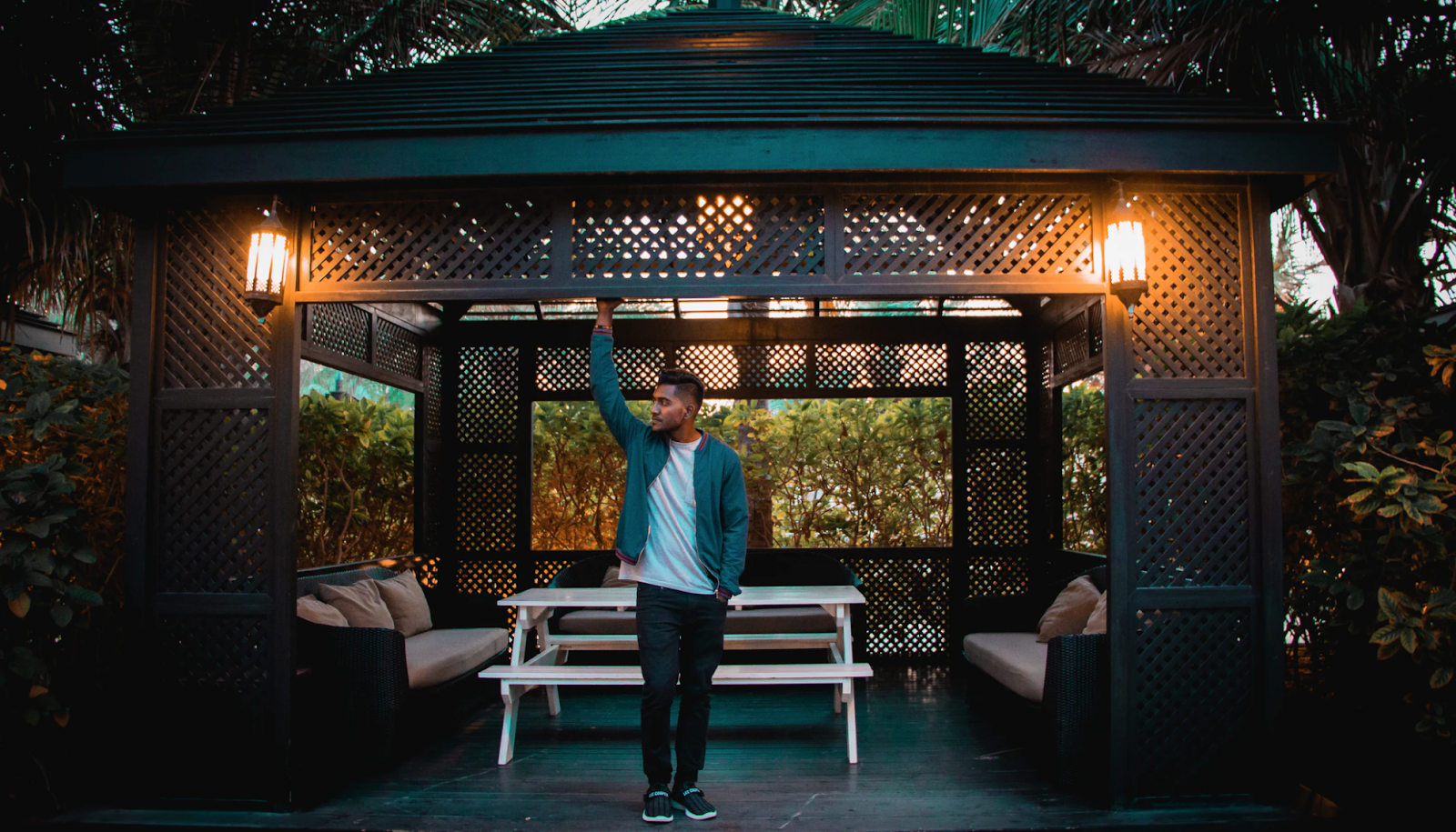 A man standing under the backyard gazebo