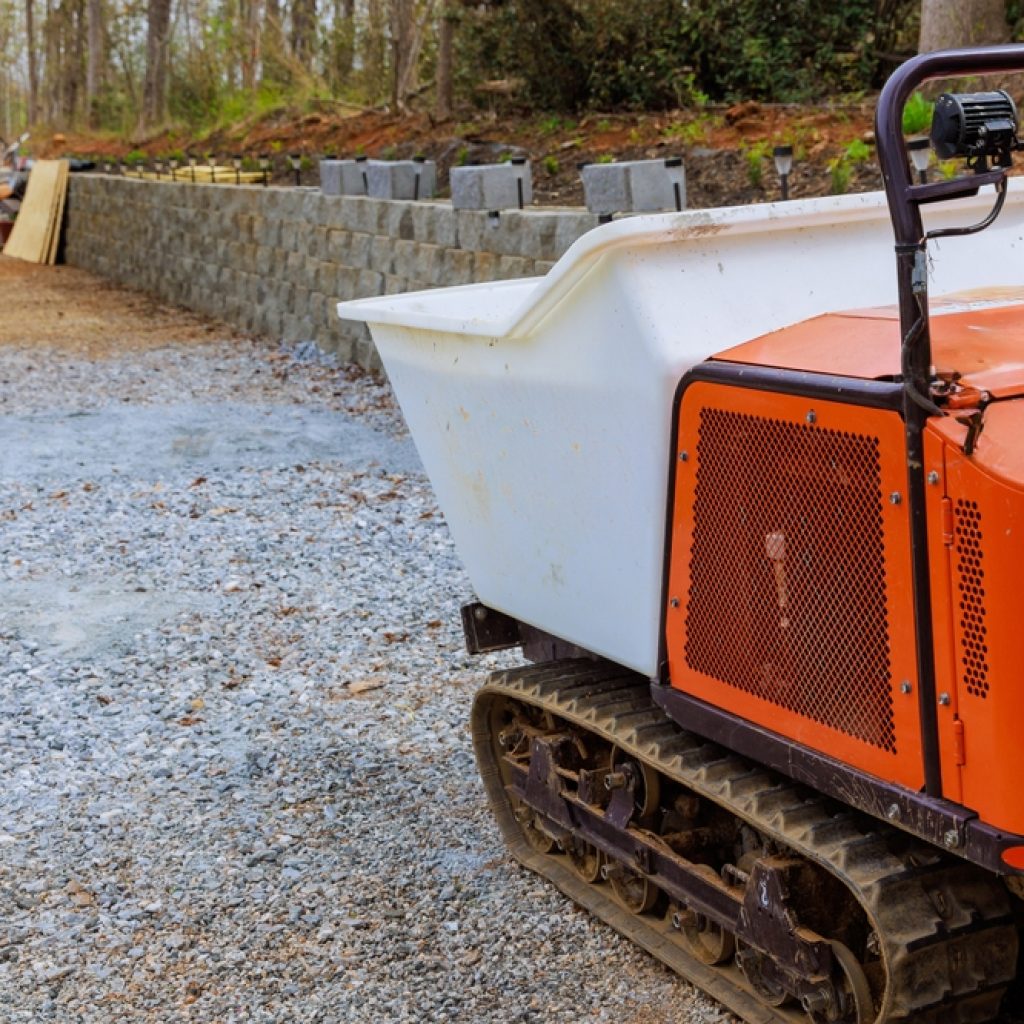 A mini dumper being used to transport materials around a worksite for building a retaining wall.